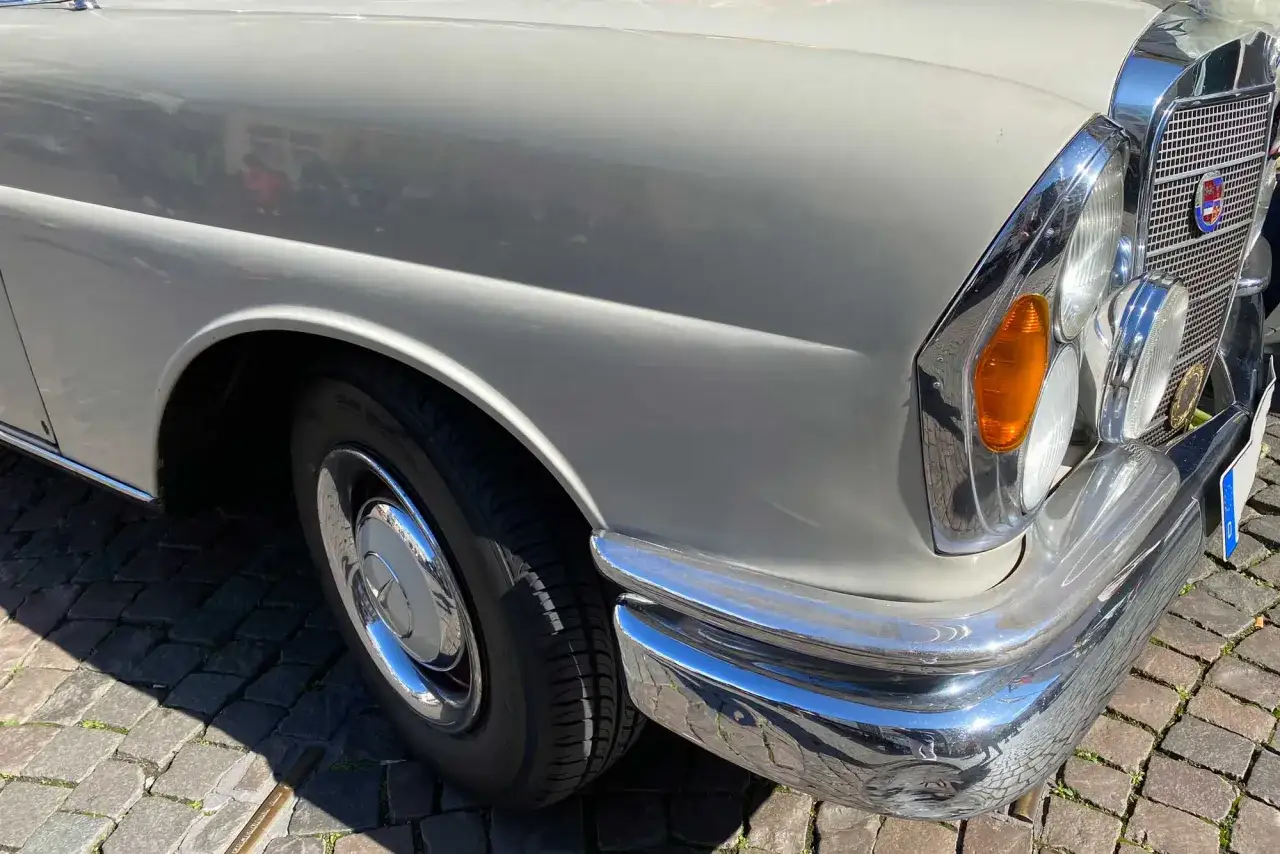 Detailaufnahme eines klassischen Mercedes. Die gl&auml;nzende Lackierung und Chromteile lassen die Frage nach den Mercedes Lackierung Kosten aufkommen.