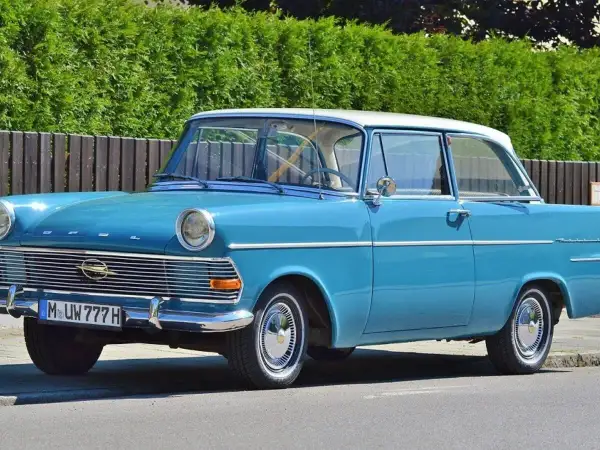 Blauer Oldtimer mit weißem Dach und dem Kennzeichen M UW 777 H. Ein Klassiker auf der Straße.