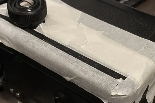 Reparatur einer alten Kamera: Mit Klebeband wird der Riss im Bakelit fixiert, bevor der Kleber trocknet.