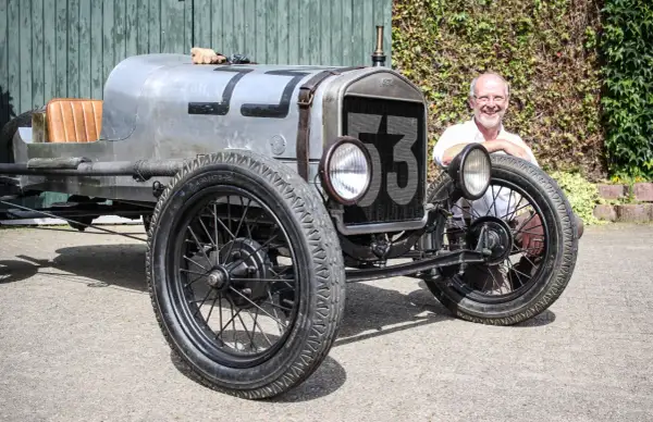 Ein Mann lächelt neben einem Oldtimer mit der Nummer 53. Wann ist ein Youngtimer steuerfrei?